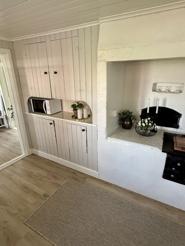 Köket med mikro och vita skåp